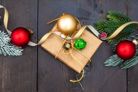 Christmas gift concept with bright ribbon and fir tree on wooden background with copy spaceの写真素材