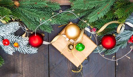 Christmas gift concept with bright ribbon and fir tree on wooden background with copy spaceの写真素材