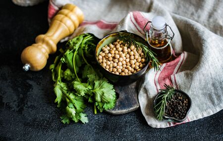 Cooking concept with raw chickpeas and herbs on stone backgroundの写真素材