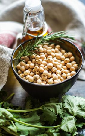 Cooking concept with raw chickpeas and herbs on stone backgroundの写真素材