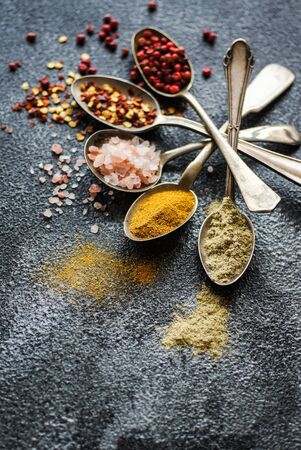 Cooking concept with vintages spoons full of spices on stone backgroundの写真素材