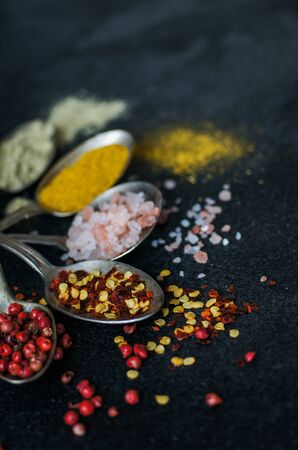 Cooking concept with vintages spoons full of spices on stone backgroundの写真素材