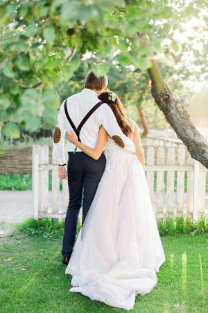 Young girl standing under green leaves, back view.の写真素材