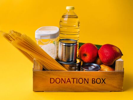 Food supplies crisis food stock for coronavirus quarantine isolation period in yellow background. different food in aluminum cans, Rice, pasta. Food delivery, oil, Donation. top view. Copy spaceの写真素材