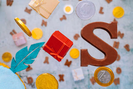 Dutch holiday Sinterklaas greeting Card. Gift boxes and traditional Saint Nicolas sweets falling or flying in motion or levitation. Pepernoten, chocolate letters. Concept children party five decemberの写真素材