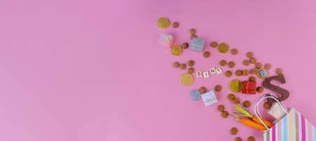 Dutch holiday Sinterklaas banner. St Nicholas Day background with traditional food - pepernoten, chocolate letter, gift, carrots for horse. Concept for party in Saint Nicolas day five decemberの写真素材