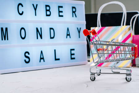 Top view of laptop, cyber monday promotion sale words on lightbox, gift boxes, laptop, shopping cart...
