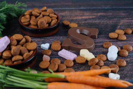 Dutch holiday Sinterklaas. Background with traditional food - pepernoten, chocolate letter, sweets strooigoed and carrots for horse. Concept for children party in Saint Nicolas day five decemberの写真素材