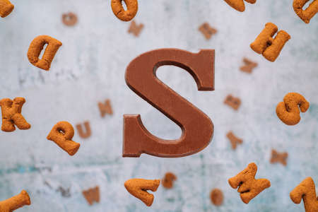 Dutch holiday Sinterklaas greeting Card. Gift boxes and traditional Saint Nicolas sweets falling or flying in motion or levitation. Pepernoten, chocolate letters. Concept children party five decemberの写真素材