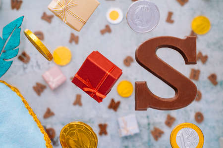 Dutch holiday Sinterklaas greeting Card. Gift boxes and traditional Saint Nicolas sweets falling or flying in motion or levitation. Pepernoten, chocolate letters. Concept children party five decemberの写真素材