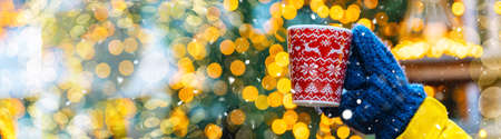 Girl walking in Christmas traditional market decorated with holiday lights in the evening. Winter portrait beautiful young woman outdoors in front of Xmas holidays decorations.の写真素材
