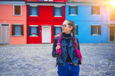 Happy traveler woman having fun near colorful houses on Burano island in Venetian lagoon. Travel and vacation in Italy concept. Lifestyle travel moments in the beautiful italian cityの写真素材