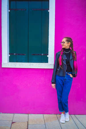 Happy traveler woman having fun near colorful houses on Burano island in Venetian lagoon. Travel and vacation in Italy concept. Lifestyle travel moments in the beautiful italian cityの写真素材
