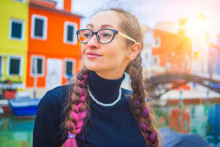 Happy traveler woman having fun near colorful houses on Burano island in Venetian lagoon. Travel and vacation in Italy concept. Lifestyle travel moments in the beautiful italian cityの写真素材