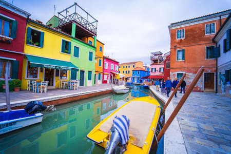 View of streets with colorful houses in Burano along canal. Typical tourist place - burano island in the Venetian lagoon Italy. Beautiful water canals and colorful architecture. Burano. Italyのeditorial素材