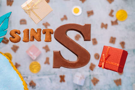 Dutch holiday Sinterklaas greeting Card. Gift boxes and traditional Saint Nicolas sweets falling or flying in motion or levitation. Pepernoten, chocolate letters. Concept children party five decemberの写真素材