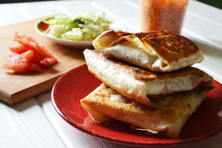 Roasted flat bread (lavash) with vegetable filling on the red round plate, selective focusの写真素材