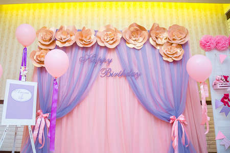 Beautiful pink photo zone for three years old girl with paper flowers, balloons, curtains. Inscription in Russian reads Amelia is 3 years oldHappy Birthday concept.の写真素材