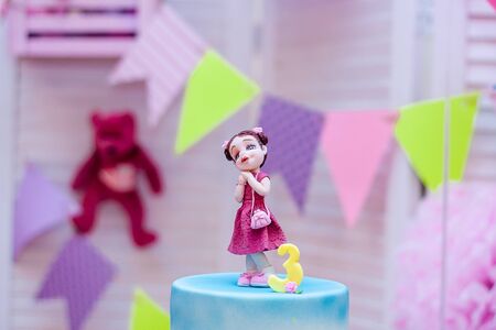 Top of birthday cake with mastic girl figure and number 3 on birthday flags background. Candy bar for child party.の写真素材
