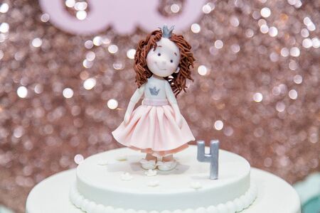 Top of birthday cake with mastic girl figure and number 4 on birthday shiny background. Candy bar for child party.の写真素材