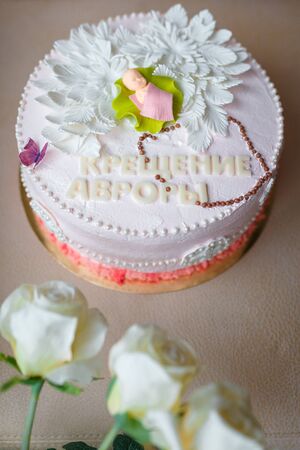 cake with cream flowers and mastic baby figure for girl christening party. Inscription reads Baptism of Avrora.の写真素材