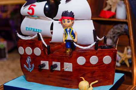 Izmail, Ukraine - March 2017. Boy birthday cake in shape of sea ship with captain mastic figure. Inscription reads Kirill is 5 years old.のeditorial素材