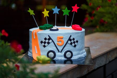 Birthday cake with mastic stars and cars figures for boy. 5 years old anniversary.の写真素材