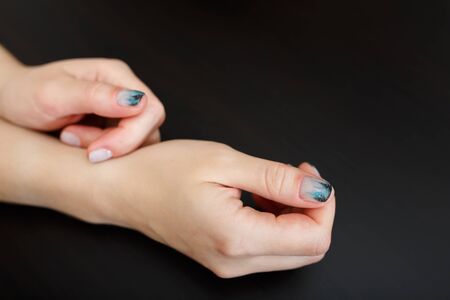 Female hands with fir-tree forest manicure on black background. Christmas or winter nail art. Hands care, fingernails design, beauty and health concept. Copy space.の写真素材