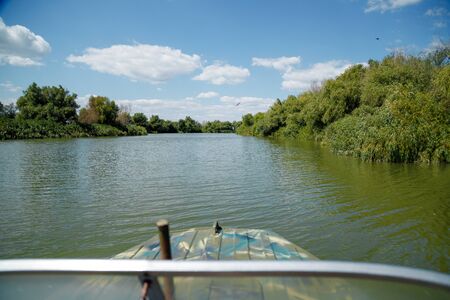 Beautiful view on river and green nature with blue sky from the motor boat seat.の写真素材