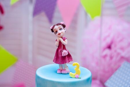 Top of birthday cake with mastic girl figure and number 3 on birthday flags background. Candy bar for child party.の写真素材