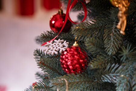 Fir-tree branches with red bulbs and cones, decorations hanging on them. Merry Christmas, Happy New Year and winter holidays concept.の写真素材