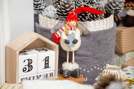 31 december cubic wooden calendar with Christmas decorative elements, soft toy and pine cones in basketの写真素材