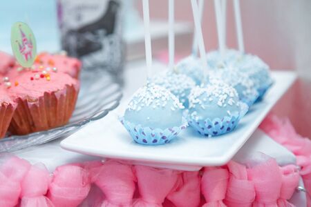 Candy bar with blue cake pops and pink muffins. Festive sweets for girl birthday party.の写真素材