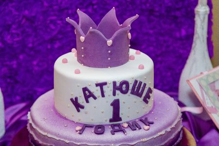 Girlish purple cake with crown and inscription - name Katusha is 1 year old. First birthday party.の写真素材