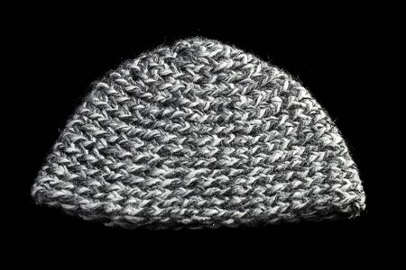 knitted melange grey and white cap on black backgroundの写真素材