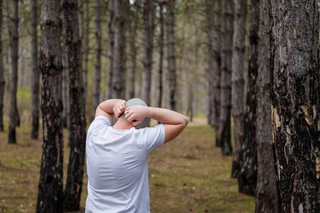 Man taking off gas mask in pine forest. Enviromental protection, ecology, Earth saving, pollution prevention, crisis, health concept.の写真素材