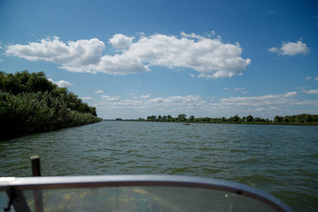 Beautiful view on river and green nature with blue sky from the motor boat seat.