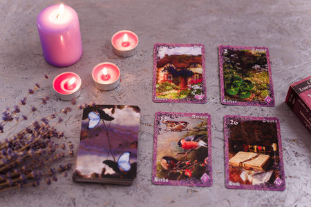 Divination cards alignment with purple burning candle and dry lavender. Mystery, astrology, fortune...