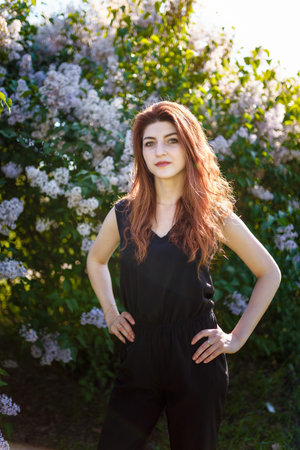 Portrait of young woman or girl among lilac blooming bushesの写真素材