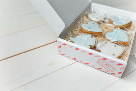 Christmas gingerbread cookies. Hearts and sweaters shapes. Winter sweets on white wooden background. Place for text.の写真素材