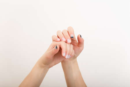 Female hands with fir-tree forest manicure on white background. Christmas or winter nail art. Hands care, fingernails design, beauty and health concept. Copy space.の写真素材