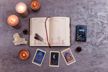 Divination cards alignment with feathers and candles on silver background. Mystery, astrology,...