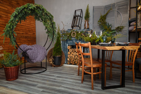 Rustic style Christmas festive decorations, fireplace with firewood, table, chairs, circle sitting...
