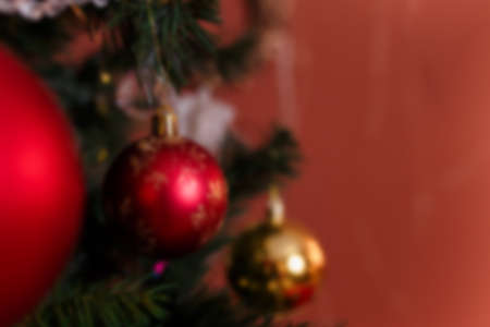 Unfocused close up shot of fir-tree branches decorated with red and golden baubles and garlands. Winter holidays, magic, Merry Christmas, Happy New Year concept, copy space.の写真素材