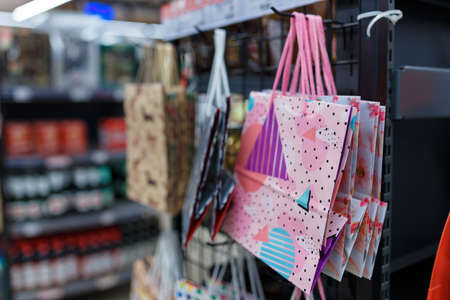 Soft focused shot of supermarket interior. Blurry hypermarket, mall or shopping center background. Row and shelves with paper bags for birthday presents.の写真素材