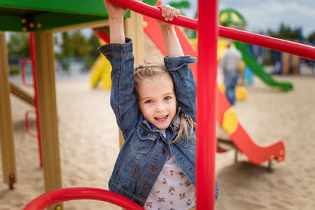 Close up portrait of little girl on playground. Happy smiling joyful kid, true emotion, carefree childhood concept.の写真素材