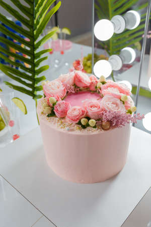 Beautiful pink cake with rose flowers. Birthday party, anniversary celebration or festive event.の写真素材