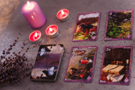 Divination cards alignment with purple burning candle and dry lavender. Mystery, astrology, fortune telling and belief concept.の写真素材