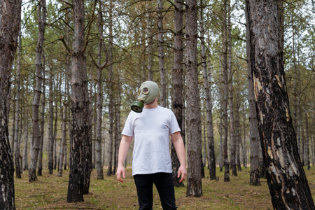 Man in white T-shirt and gas mask in pine forest. Enviromental protection, ecology, Earth saving, pollution prevention and hope concept.の写真素材