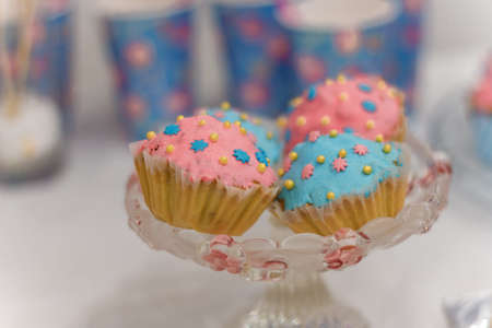 Candy bar with blue and pink glazed muffins. Festive sweets for girl birthday party.の写真素材